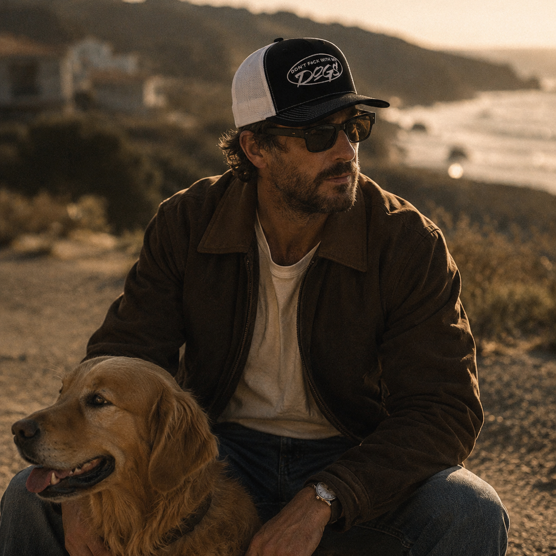 Man sitting with a dog on a beach at sunset