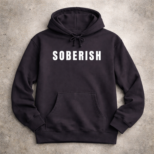 Black hoodie with 'SOBERISH' text on a concrete surface
