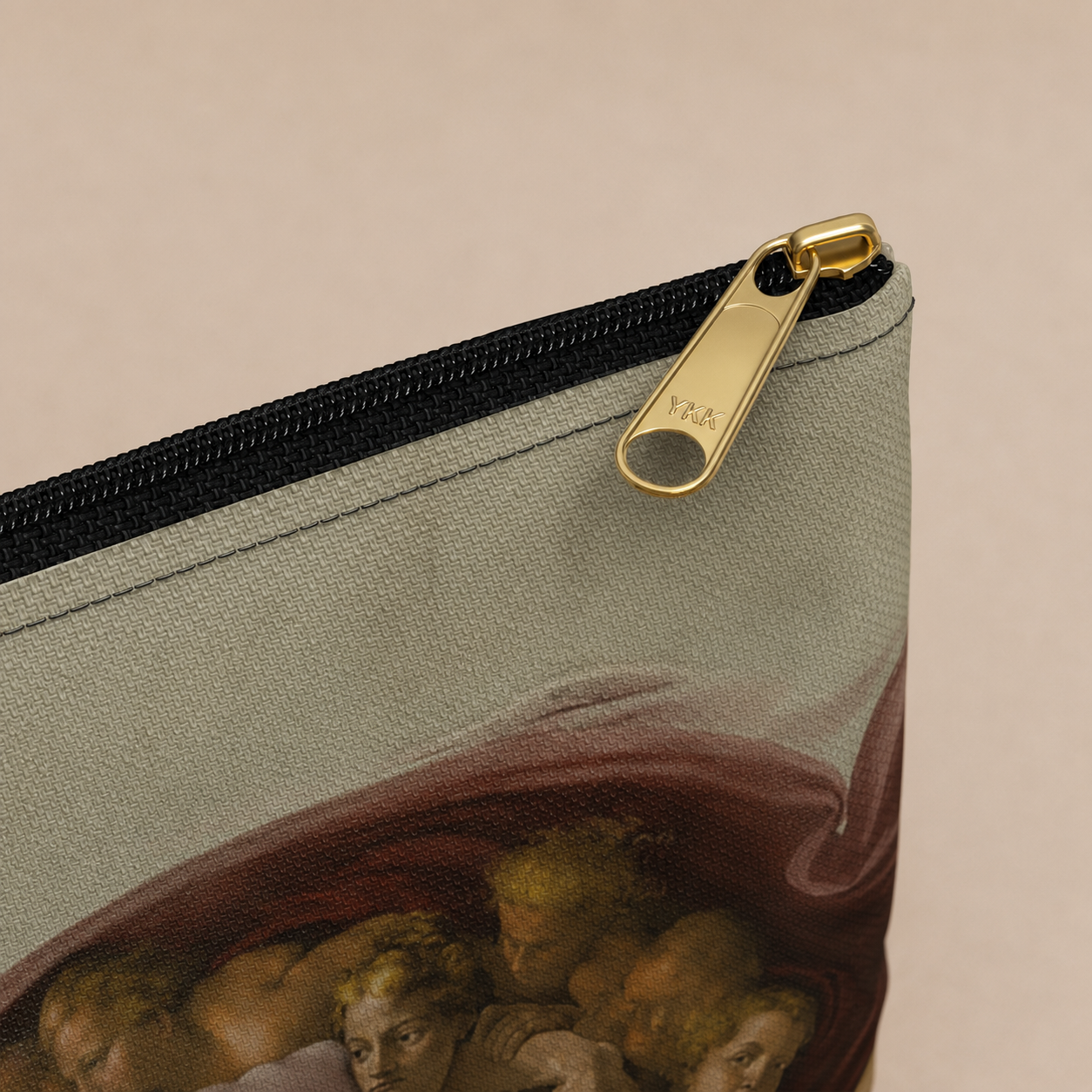 A close-up of a canvas zippered pouch featuring a classical painting print of cherubs under a red drape, with a gold zipper pull and black zipper.