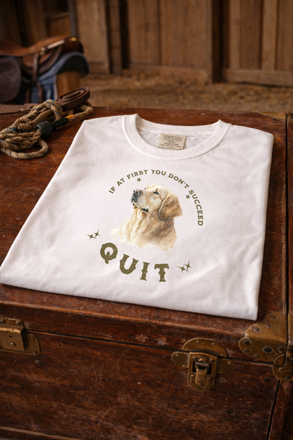 White t-shirt with a dog graphic and text on a wooden surface If At First You Don't Succeed, Quit Graphic Tee
