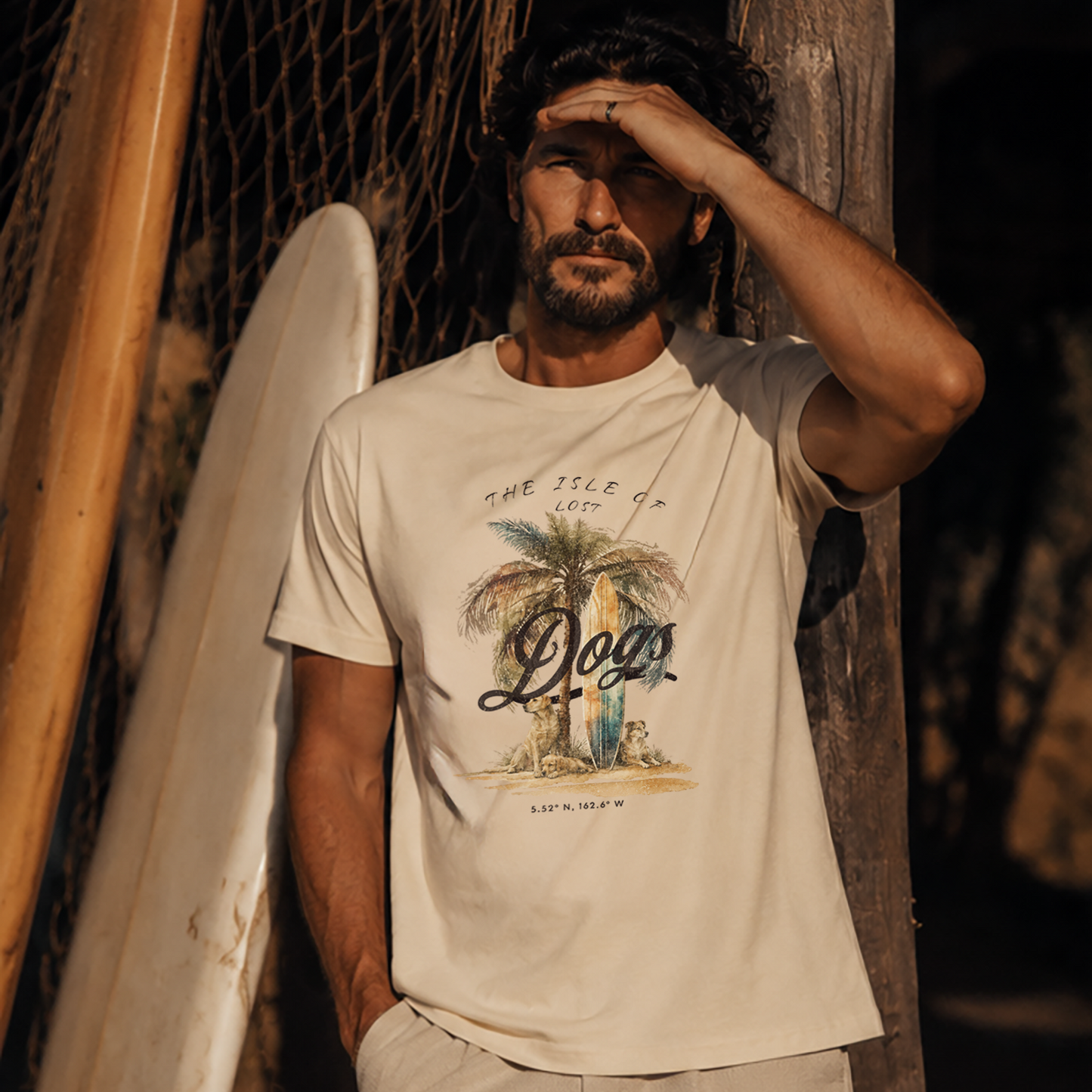 Man wearing a white t-shirt with a palm tree design, standing next to a surfboard.