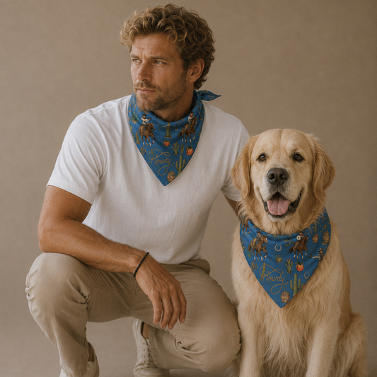 A man and a golden retriever dog crouching together against a plain beige studio background, both wearing blue patterned bandanas. The man wears a white t-shirt and beige pants, while the dog wears a white shirt underneath and beige pants.