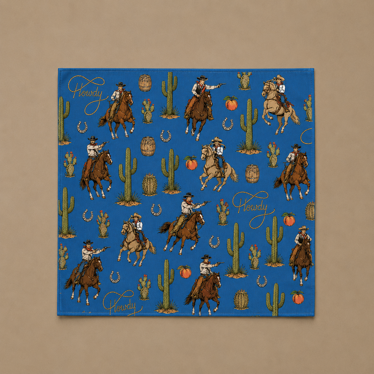 A square blue fabric bandana featuring a repeating 'Cowboy' theme with illustrations of cowboys on horseback, cacti, and horseshoes, displayed flat against a neutral tan background.