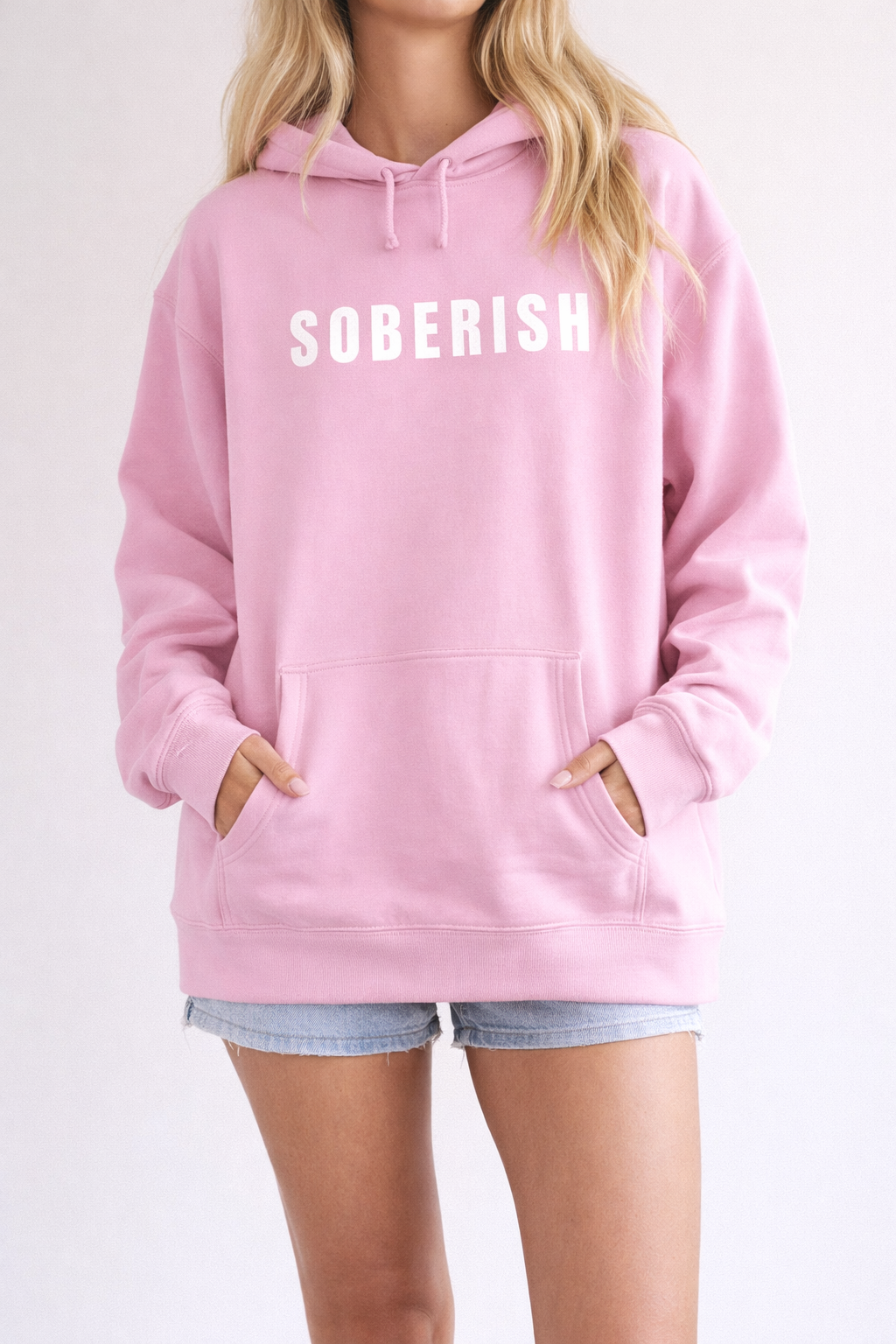 Person wearing a pink hoodie with 'SOBERISH' text on a white background