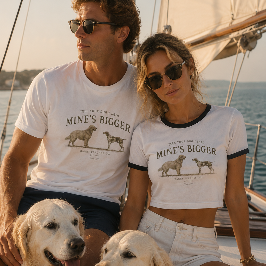 Couple with two dogs sitting on a boat, wearing matching t-shirts.