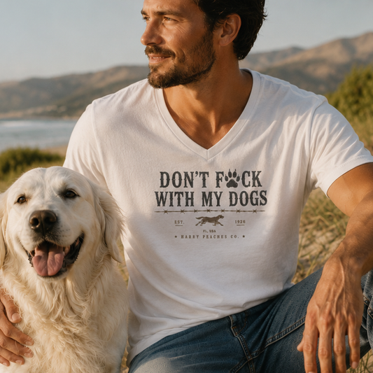 Man wearing a white t-shirt with a dog-themed graphic and text, sitting outdoors with a dog.